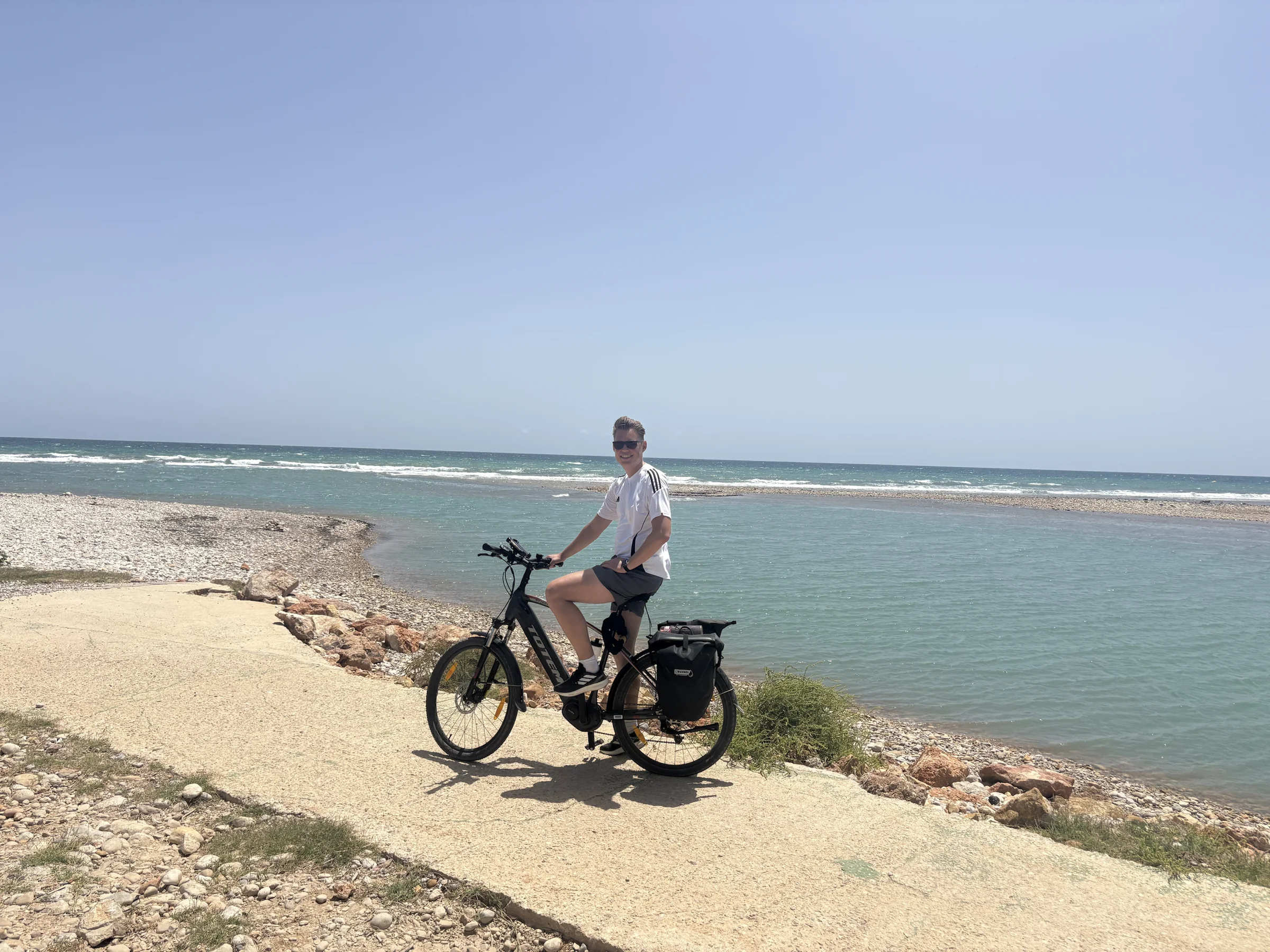 Rider on a fully equipped trekking e-bike beside the Costa Azahar coastline.